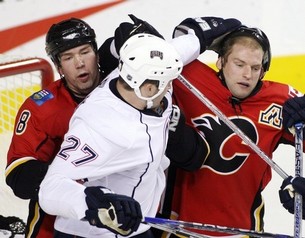 Dustin Penner helps Robyn Regehr to adjust his helmet