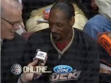 Snoop Dogg in the stands being interviewed by Scott Oake on a Hockey Night in Canada broadcast